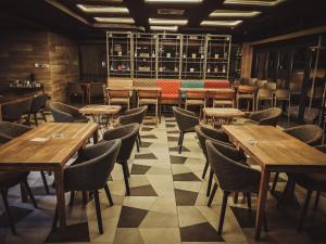 a dining room with wooden tables and chairs at Hotel City Code in Zenica