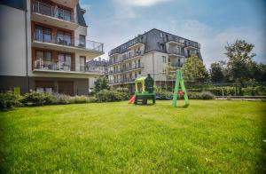 a playground in a yard in front of a building at Apartamenty Na Wyspie - Casa Marina - Parking in Świnoujście