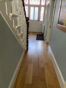 a hallway with a staircase with wood flooring at Abbey GH All Rooms En-Suite in Redcar +54 photos