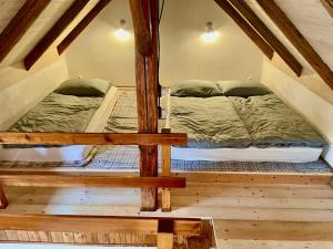 2 łóżka piętrowe w pokoju na poddaszu w obiekcie Apartmány pod Kozákem w mieście Velké Popovice
