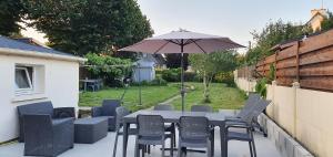 a table and chairs and an umbrella on a patio at Studio Diadéma Armor in Plérin