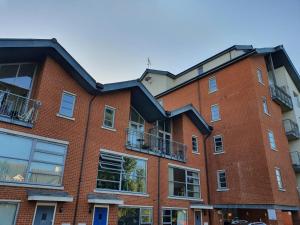 a red brick building with windows and balconies at Vetrelax Colchester Apartment in Colchester