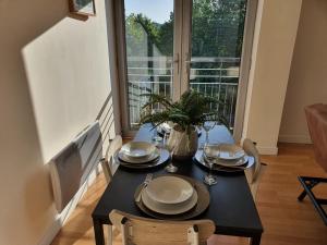 a dining room table with plates and glasses on it at Vetrelax Colchester Apartment in Colchester