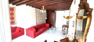 un soggiorno con divani rossi e lampadario a braccio di Elisabeth Waterfront Apartment a Venezia