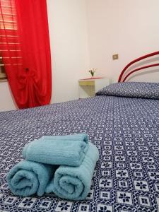 Pokój z łóżkiem z niebieskimi ręcznikami w obiekcie Sa cronta affitacamere w mieście Arzana