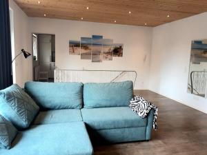 un sofá azul en una sala de estar con pinturas en la pared en Apartment in Bad Schwartau, en Bad Schwartau