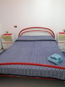 Una cama en una habitación con una almohada azul. en Sa cronta affitacamere, en Arzana