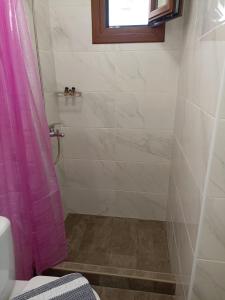y baño con ducha y cortina de ducha rosa. en STUDIOS THISEAS en Naxos