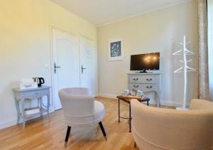 a living room with chairs and a tv and a table at Au bon maréchal in Giverny