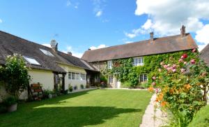 a courtyard of an old house with flowers at Au bon maréchal in Giverny