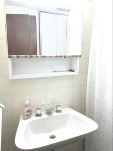 y baño con lavabo blanco y espejo. en Edificio Playa Club en Miramar