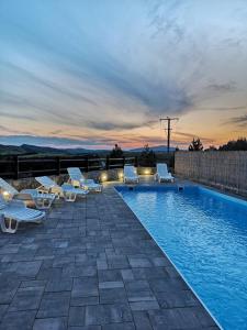 uma piscina com espreguiçadeiras e um pôr-do-sol em Apartman Andjelina Lux Zlatibor em Zlatibor