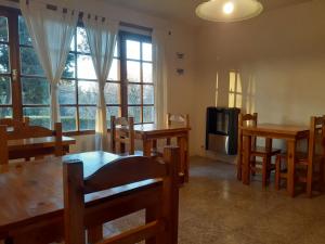 una sala da pranzo con tavoli e sedie e una TV di Alojamiento Los Alelies a San Carlos de Bariloche Altre 30 foto