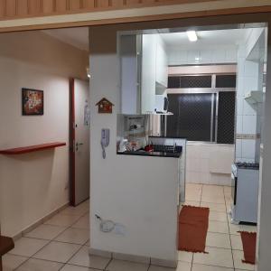 uma cozinha com um frigorífico branco num quarto em Apartamento Guaruja Enseada 2 Quadra da Praia Atrás do Aquario no Guarujá