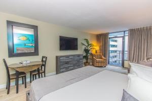 a bedroom with a bed and a table with a desk at Landmark 618 in Myrtle Beach