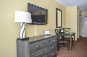 um quarto de hotel com uma televisão e uma cómoda com um candeeiro em Landmark 704 em Myrtle Beach