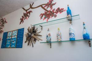 a wall with three glass bottles on a wall at Apartments Tania in Paralia Dionysiou