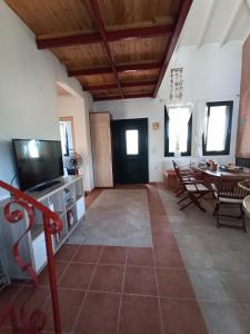 a living room with a television and a dining room at Olgas Villa in Aroyí