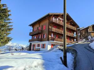 a building in the snow with a pole at Apartment mit Traumblick im Haus Olympia in Grächen