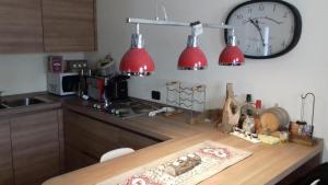 kuchnia z dwoma czerwonymi światłami i zegarem na ścianie w obiekcie Love chalet w Livigno +10 zdjęć