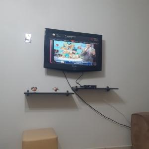 a flat screen tv hanging on a wall at Apartamento Guaruja Enseada 2 Quadra da Praia Atrás do Aquario in Guarujá