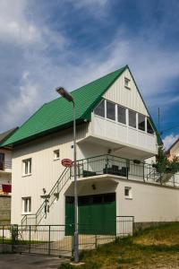 un grand bâtiment blanc avec un toit vert dans l'établissement Knežević Apartment, à Žabljak