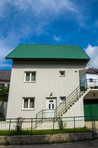 un grand bâtiment blanc avec un toit vert dans l'établissement Knežević Apartment, à Žabljak