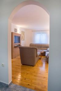 - un salon avec un canapé et une télévision dans l'établissement Knežević Apartment, à Žabljak
