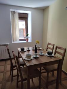 une table à manger en bois avec des chaises et une fenêtre dans l'établissement Albergue rural l'Almada de Yebra, à Yebra de Basa