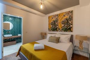sypialnia z dużym łóżkiem i żółtym kocem w obiekcie SOCIAL LODGE - Centro do Funchal w Funchal
