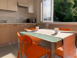 a kitchen with a table and orange chairs at Volta's Dream in Como