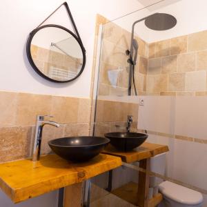 Un baño con un lavabo negro y un espejo. en Kawaii - Domaine Tropical, en Saint-Aignan