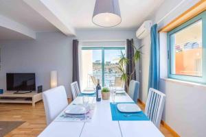 a dining room with a white table and chairs at Admirable 1 bedroom Marina view apt. Albufeira in Albufeira