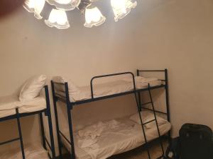 2 Etagenbetten in einem Zimmer mit Kronleuchter in der Unterkunft Ave Maria Guest House in St Julian's