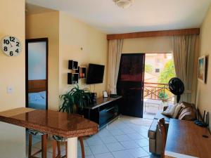 een woonkamer met een tafel en een kamer met een balkon bij CONDOMÍNIO VILA DO MAR in Aquiraz