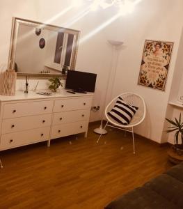 a bedroom with a dresser with a mirror and a chair at Casa relax in Collegno