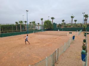 two people playing tennis on a tennis court at ASILAH MARINA GOLF in Asilah