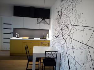 a kitchen with a white table and chairs at Apartament MONDRIAN in Płock