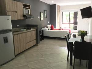 una cucina e un soggiorno con un letto in una camera di Apartahotel Avanti a Medellín