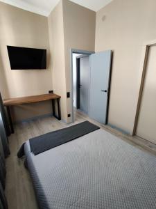 a room with a bed and a refrigerator at Pasta Amber Lux in Liepāja