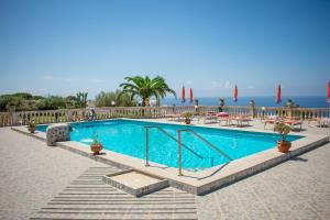 einen Pool mit Tischen und Stühlen und das Meer in der Unterkunft Hotel Villa Rita in Ischia