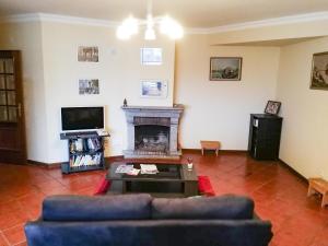 uma sala de estar com um sofá e uma lareira em Alojamento Rocha em Viseu
