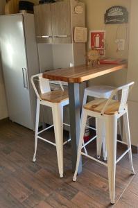 a table and two stools in a kitchen with a refrigerator at Casita de Piedra in Trinidad