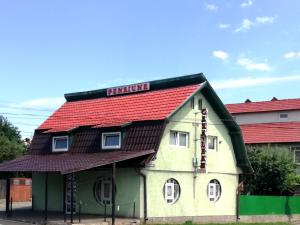 ein kleines Haus mit rotem Dach auf einer Straße in der Unterkunft Casa Leah in Râșnov