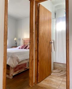 a bedroom with a bed and a large wooden door at Casita de Piedra 2 in Trinidad