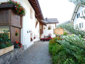 una strada di ciottoli in una piccola cittadina con edifici di Hotel Fortuna a Ortisei