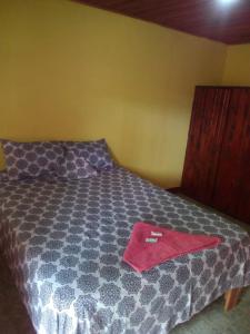 Una cama con una toalla roja encima. en Cabinas Surf Side, en Cahuita