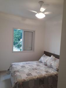a bedroom with a bed and a window at Excelente Opção de Apartamento em Ubatuba-SP in Ubatuba