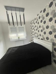 a bedroom with a black bed and a window at Solanki Apartament Solankowa Aleja Loft in Inowrocław