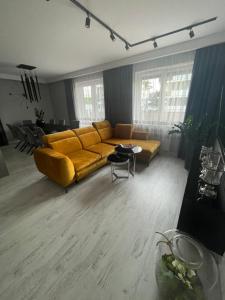 a living room with a yellow couch and a table at Solanki Apartament Solankowa Aleja Loft in Inowrocław